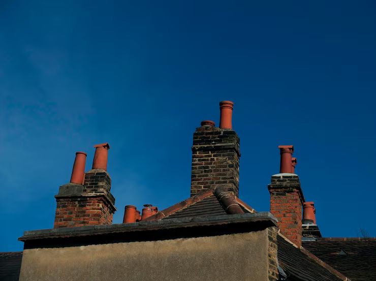 Terracotta pots crowning brick stacks against a deep blue sky